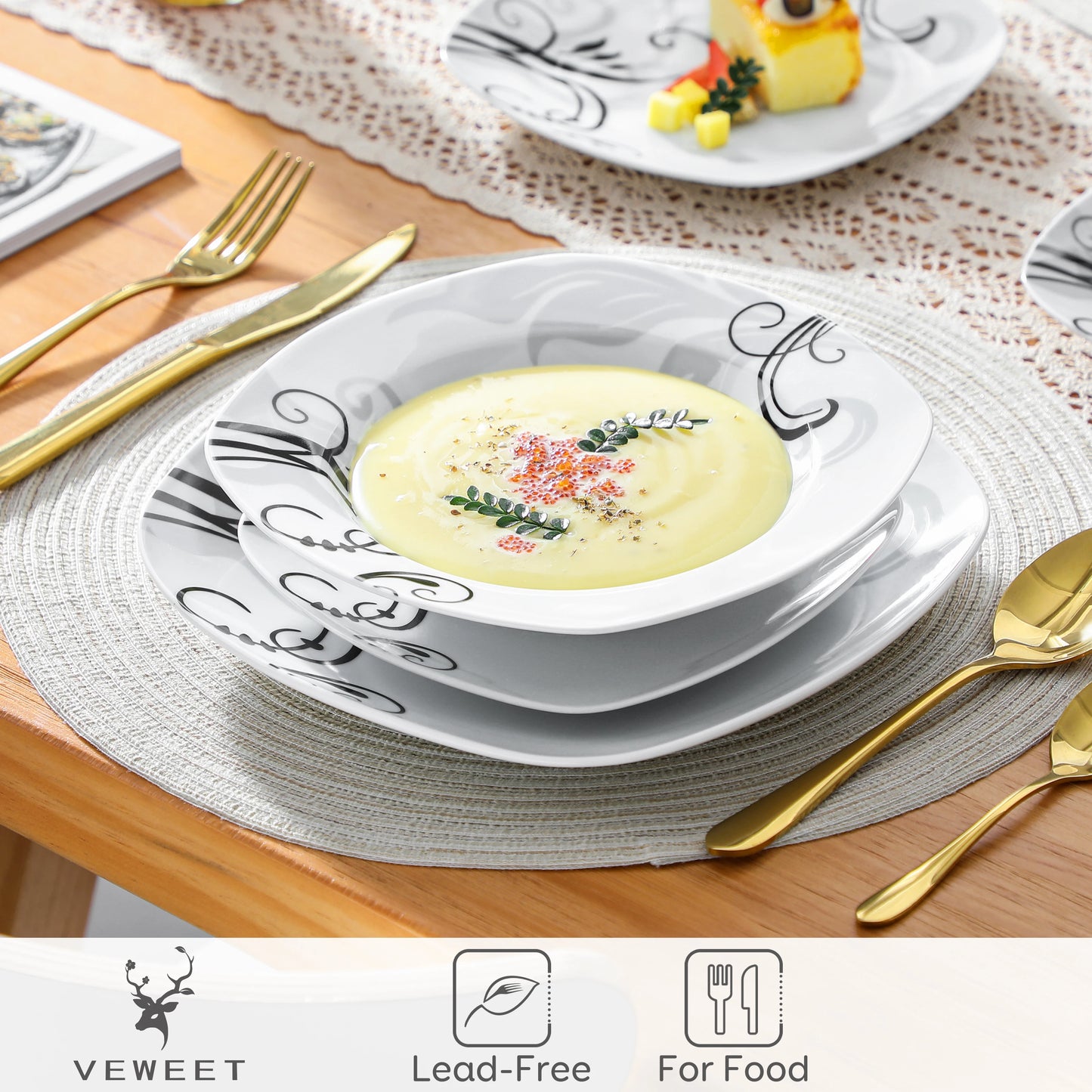 Ceramic plates with decorative black patterns on a table setting with gold cutlery.