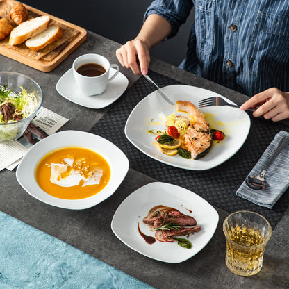 Dining table with various dishes including a plate of salmon, soup, and salad.