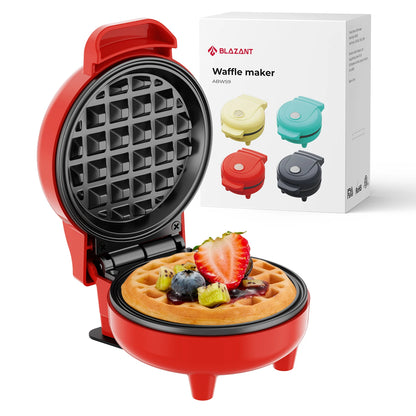 Red waffle maker with a cooked waffle and fruit toppings, next to its packaging.