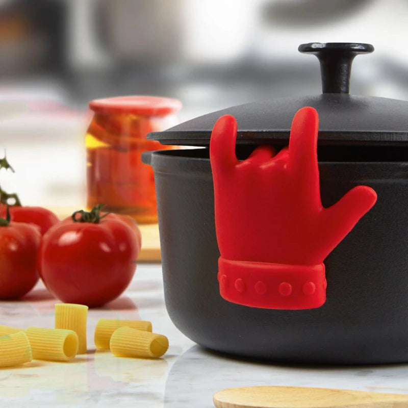 Silicone anti-spill pot clip holding a spoon securely over a pot.