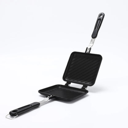Black double-sided grill pan with two distinct cooking surfaces on a white background