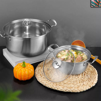 Stainless steel pot with a lid on a hot plate, surrounded by pumpkins and a woven mat.