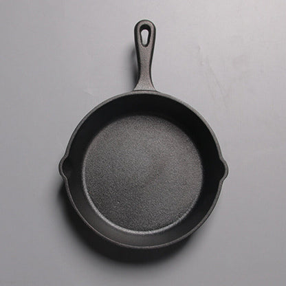 Black cast iron skillet on a gray background