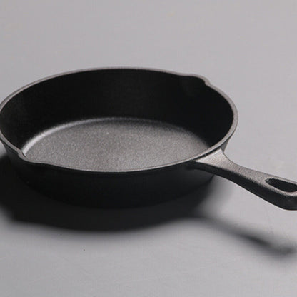 Black cast iron skillet on a gray background