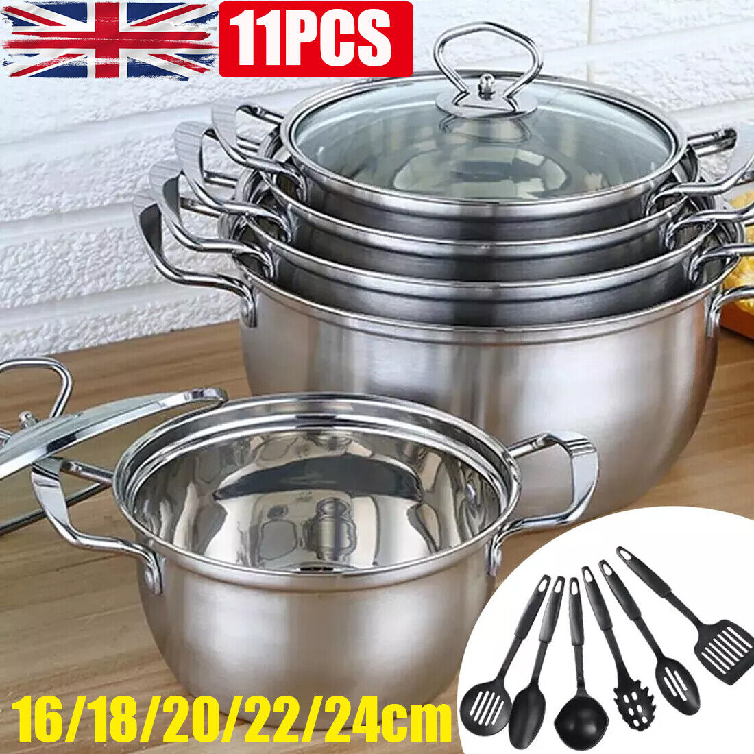 Set of stainless steel pots with lids on a wooden surface, accompanied by kitchen utensils.